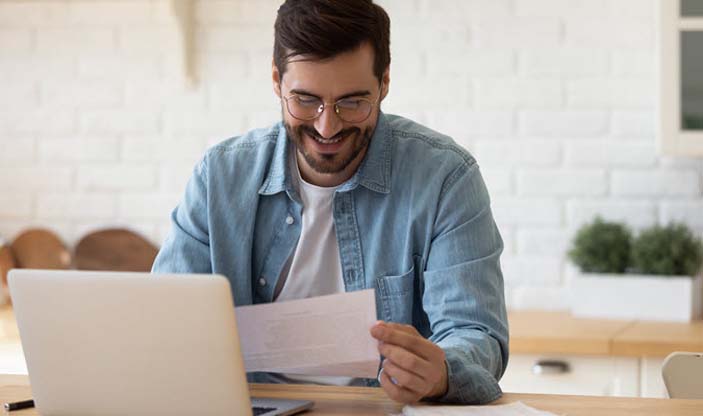 Foto: fizkes/Shutterstock.com Illustrasjonsfoto. Smilende mann som leser et dokument