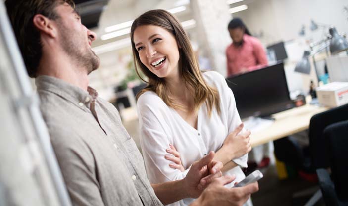 Photo: Shutterstock.com Smilende arbeidskollegaer i et kontormiljø.