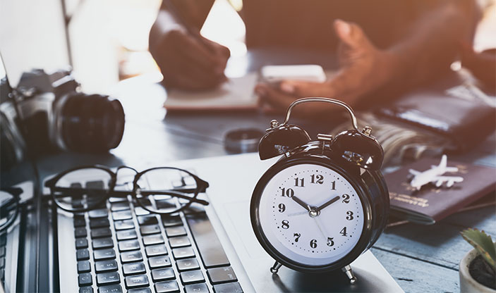 Foto: Eakachai Leesin/Shutterstock.com mann som jobber, klokke som viser tiden, pc. Foto